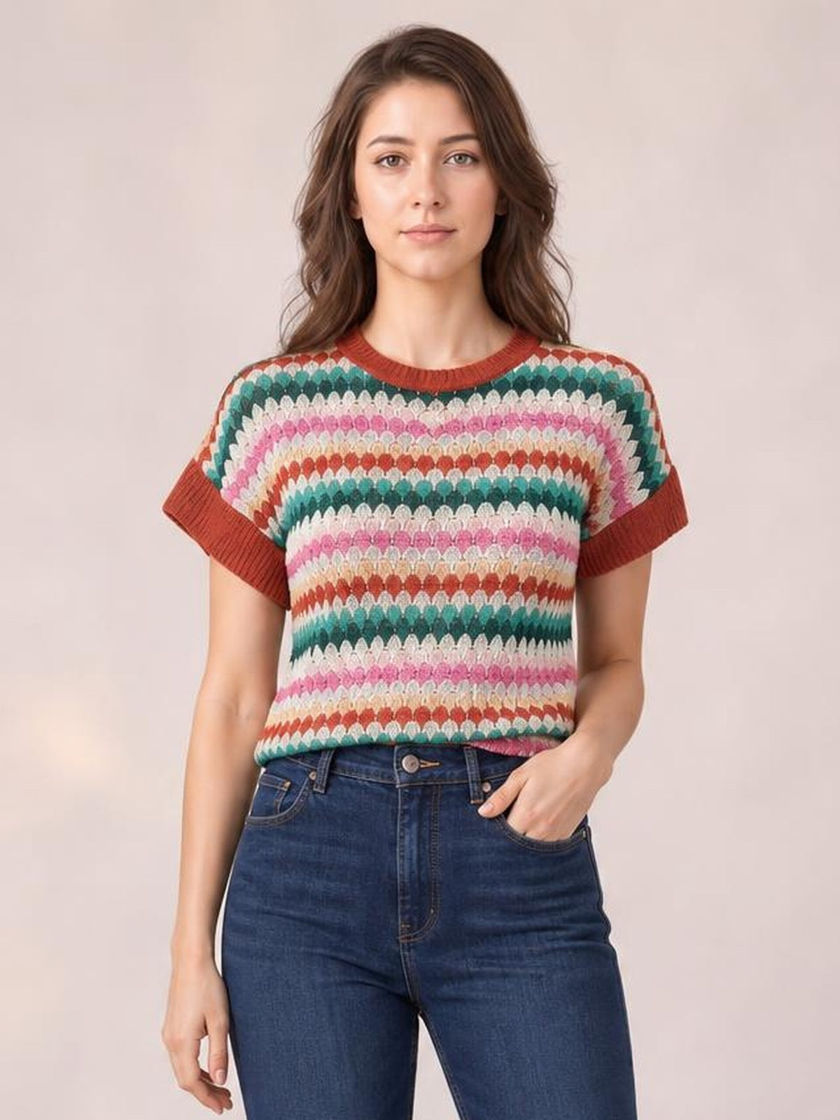Model wearing a multicolor contrast round neck short sleeve sweater with a relaxed silhouette, ribbed red trim, and horizontal textured stripes.