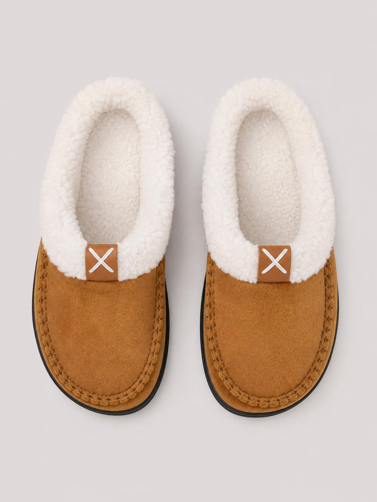 Pair of contrast round toe flat slippers in brown with plush white fluff lining, stitched moccasin-style edges, and black TPR soles.