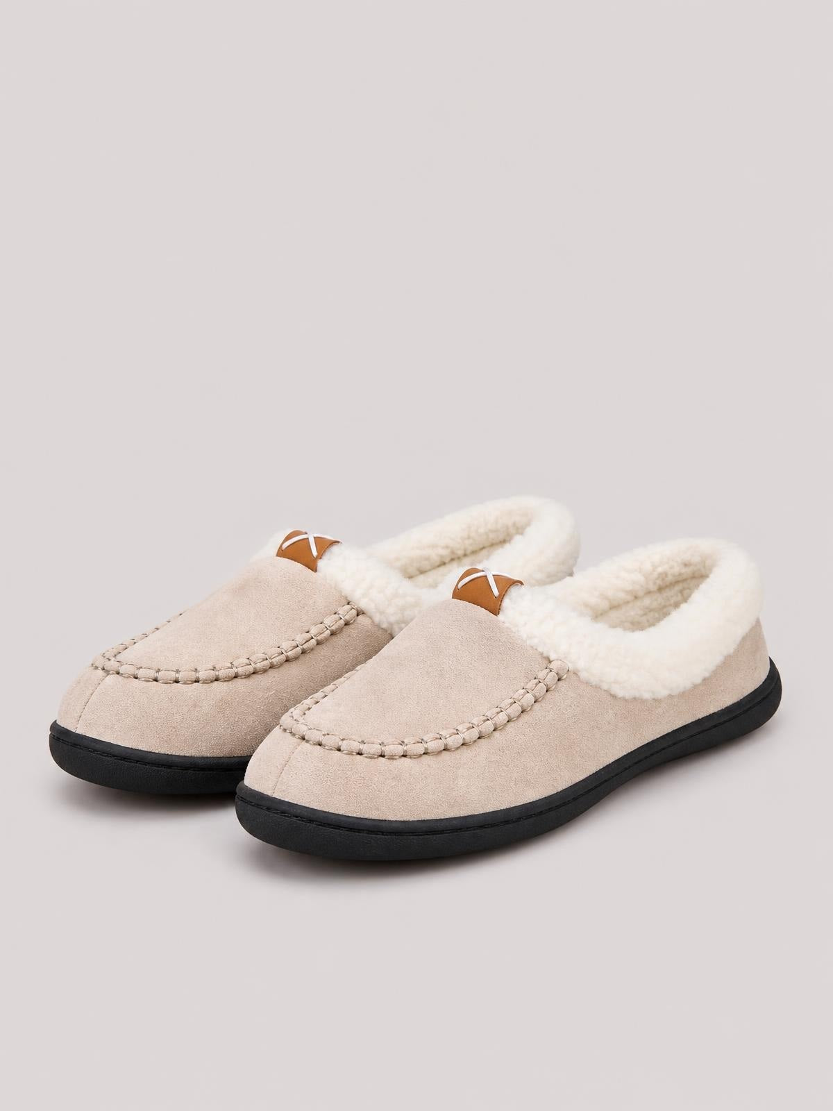 Beige contrast round toe flat slippers with plush fleece lining, moccasin-style stitched uppers, brown tabs, and sturdy black TPR soles.