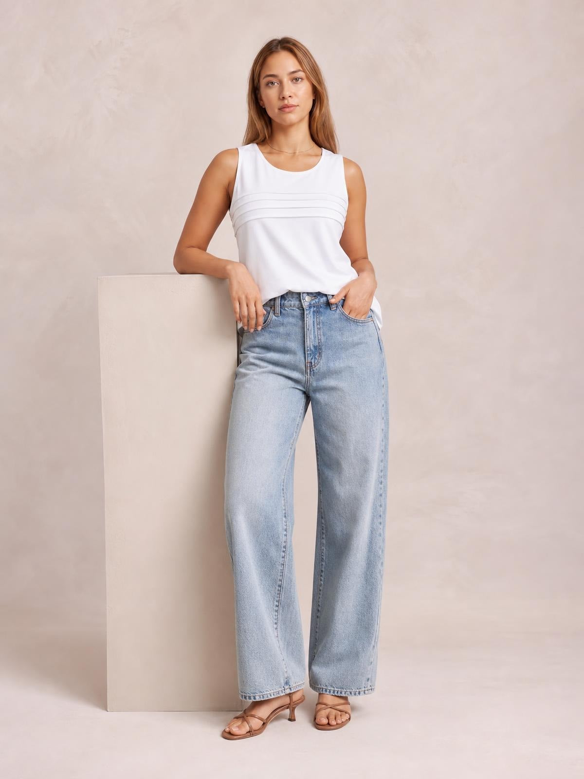 Model leans casually in light blue contrast straight-leg jeans with a structured waistband, zip fly, front pockets, and full-length silhouette.
