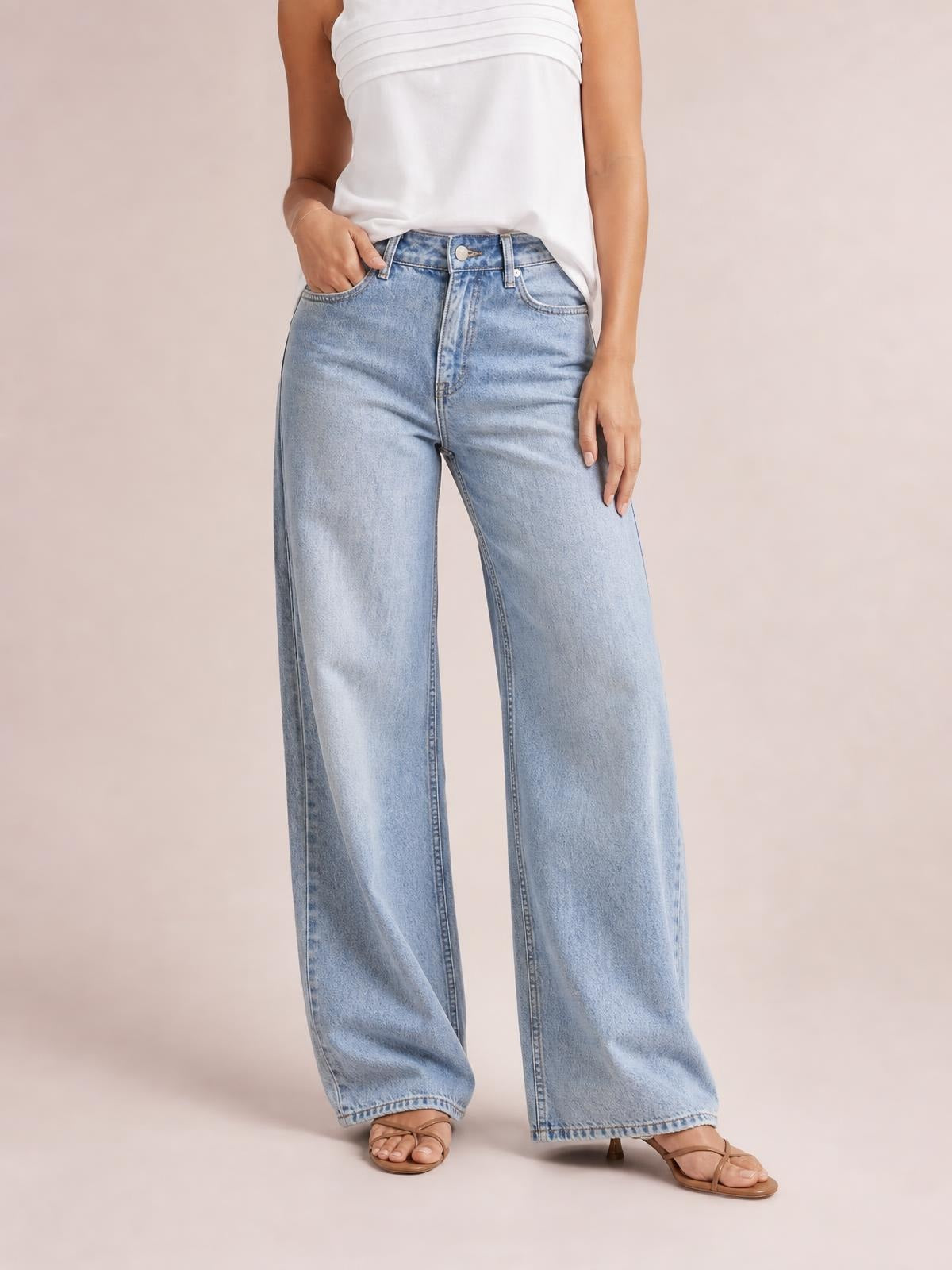 Model wearing light-wash contrast straight-leg jeans with front pockets, belt loops, zip fly, and a relaxed full-length silhouette.