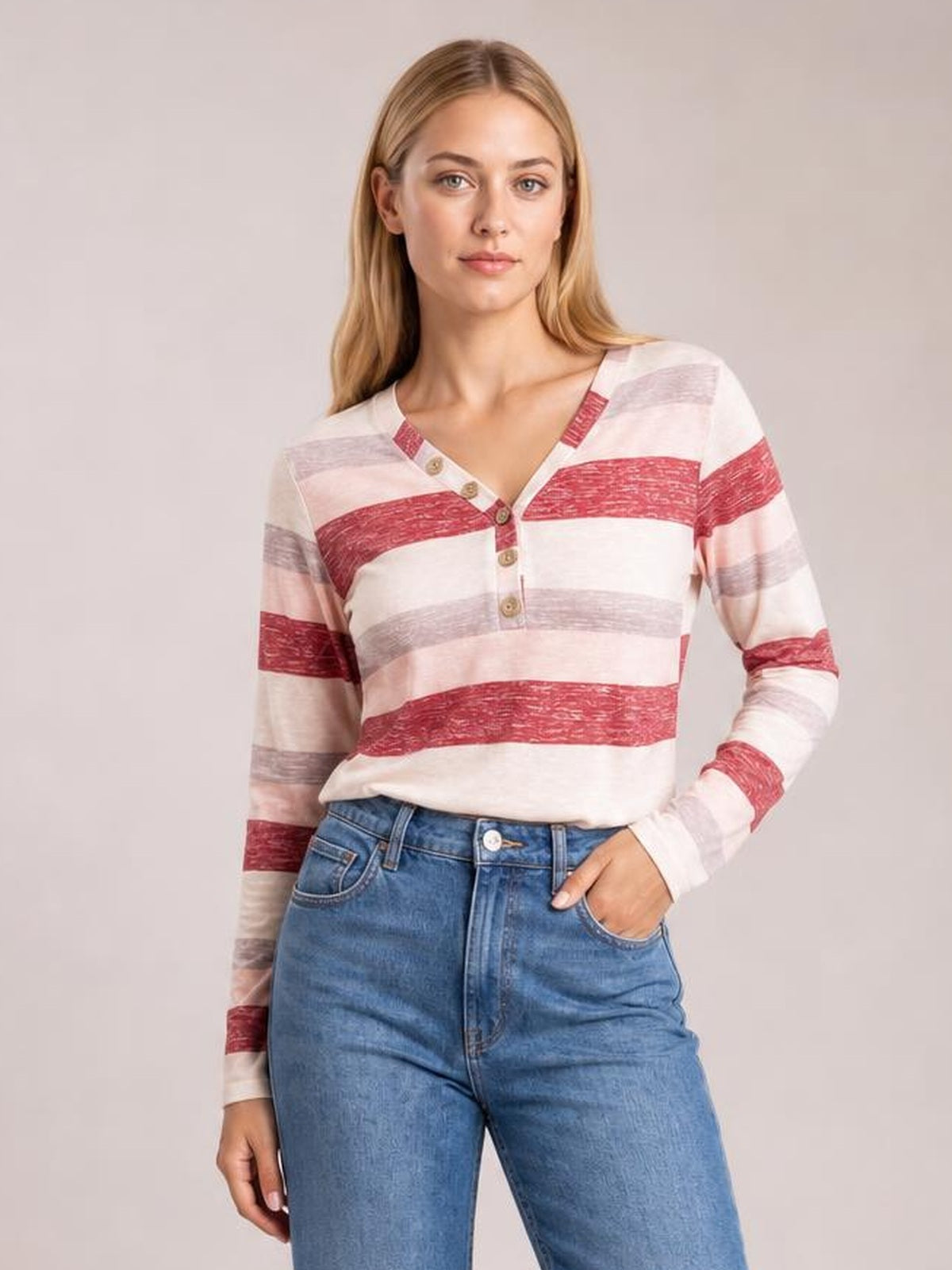 Model wearing an opaque long-sleeve V-neck T-shirt with red, blush pink, and gray contrast stripes, button placket, and a relaxed silhouette.