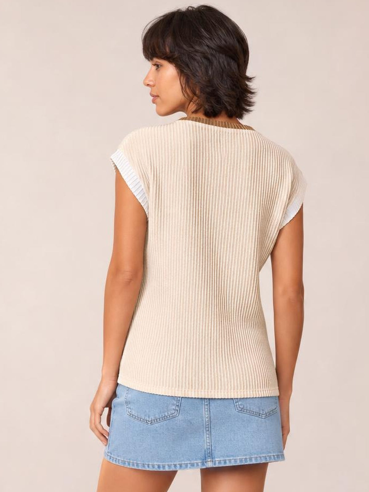 Back view of a model wearing an ivory ribbed knit sleeveless top with contrast trim at the neckline and armholes, a straight, lightly fitted silhouette.