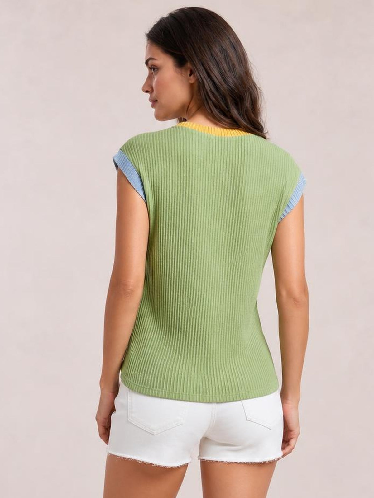 Model turned away wears a light green ribbed knit top with a fitted silhouette, yellow neckline, and contrasting blue trim on the short sleeves.
