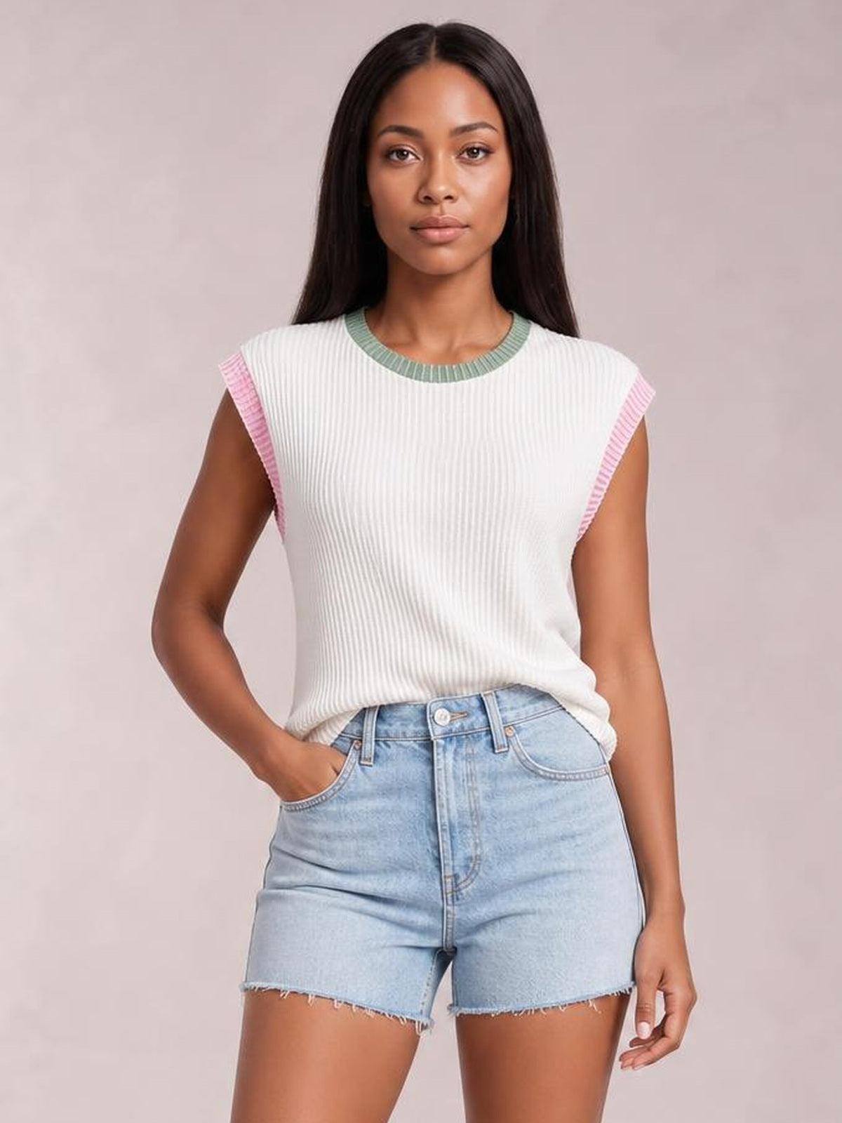 Model wears a white ribbed knit sleeveless top with pink and sage contrast trim, a round neckline, and a relaxed straight silhouette.