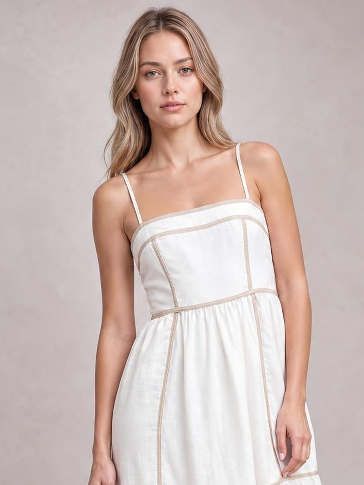 Model wears a white square-neck midi cami dress with thin straps, contrasting trim, structured panel seams, and a gently gathered skirt.