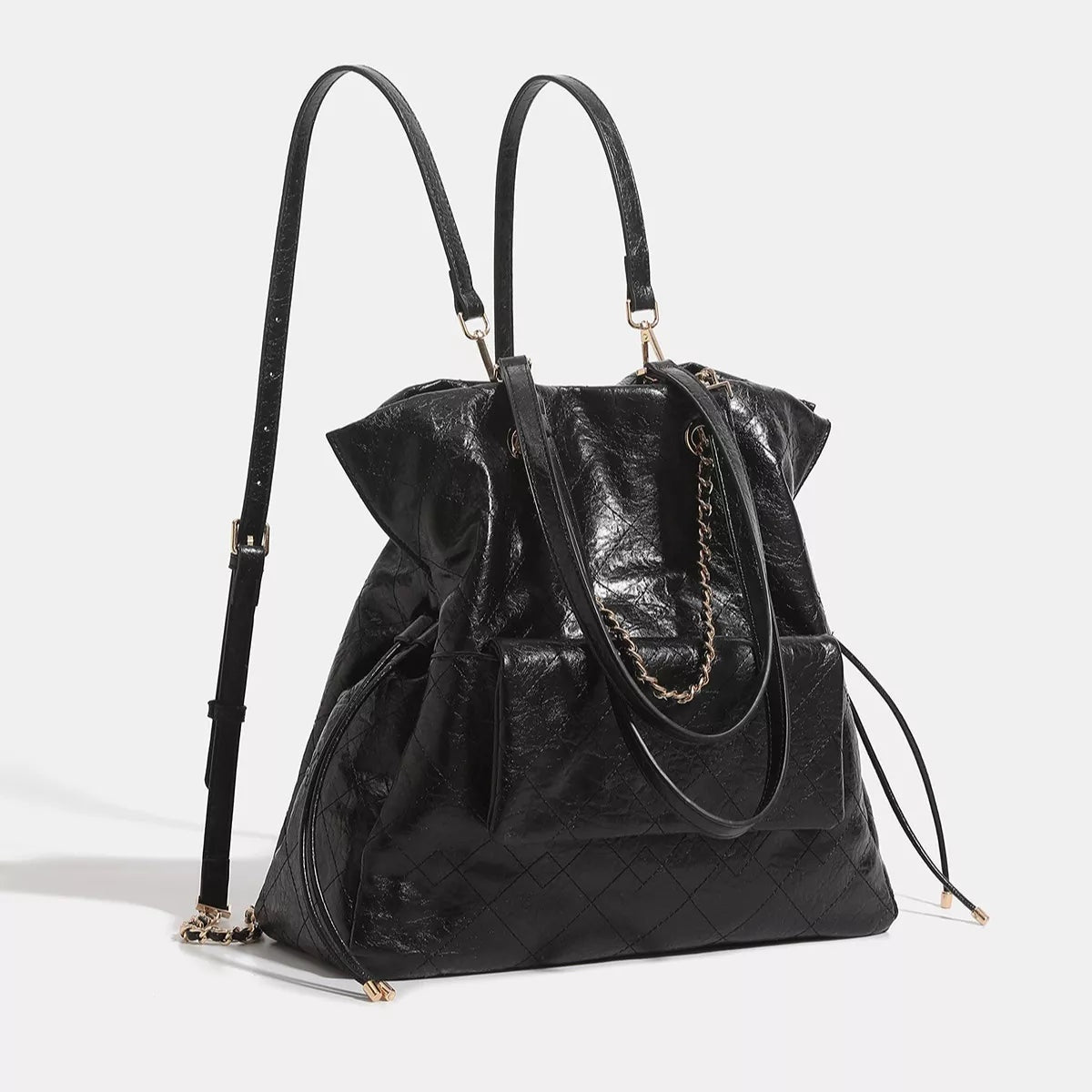 Large black PU leather convertible drawstring backpack bag with quilted panels, dual top handles, adjustable straps, and a gold-tone chain detail.