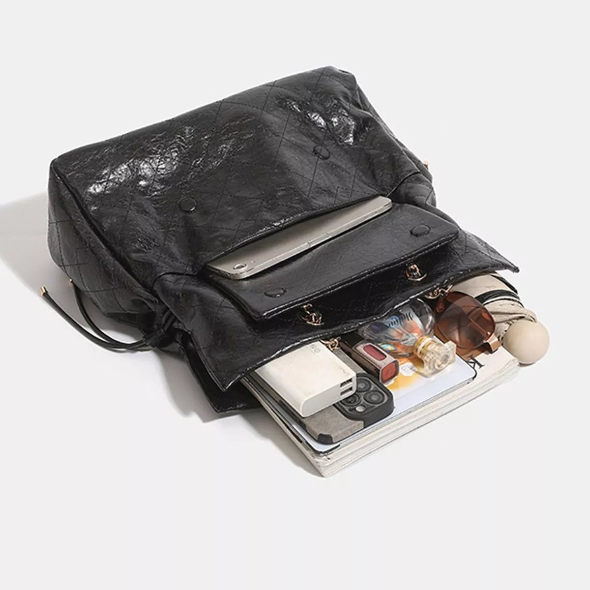 Large black PU leather convertible drawstring backpack bag shown open, featuring a roomy compartment, flap closure, snap fasteners, and adjustable drawstring straps.