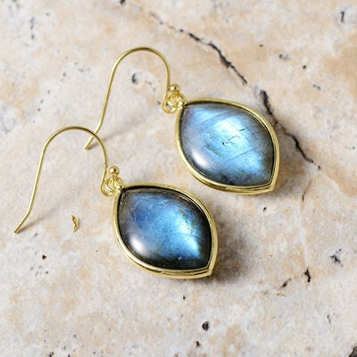 Copper teardrop earrings with polished gold-toned frames, blue imperial stone centers, and slender fishhook ear wires create an elegant sculptural silhouette.