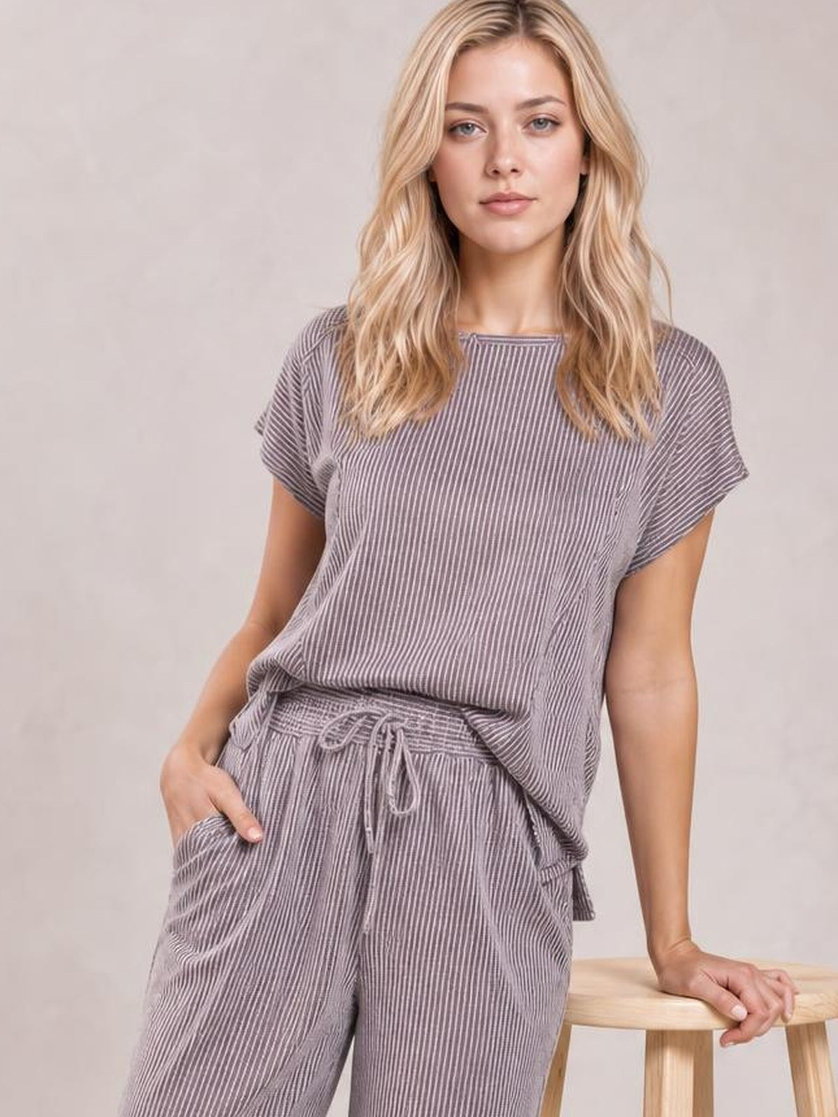 Model in a mauve corded knit set with a short-sleeve T-shirt and drawstring wide-leg pants, standing with one hand in a pocket.