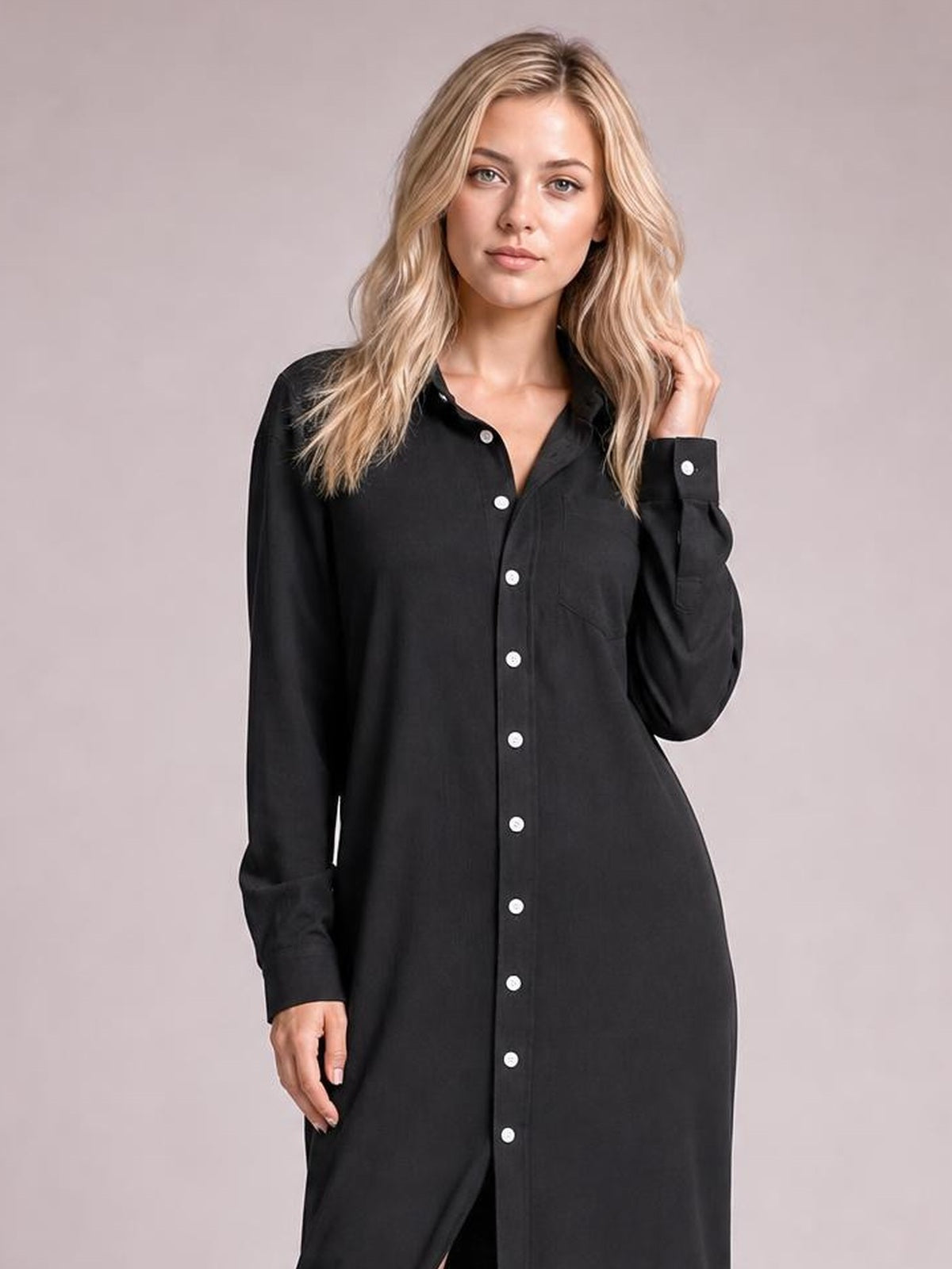 A model poses in a black corduroy shirt dress with a button-down front, pointed collar, long sleeves, chest pocket, and relaxed straight silhouette.