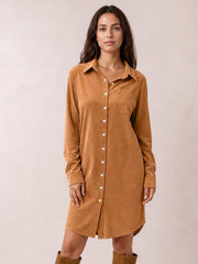 A model stands in a camel corduroy shirt dress with a collared button-down front, long sleeves, chest pocket, and relaxed straight silhouette.