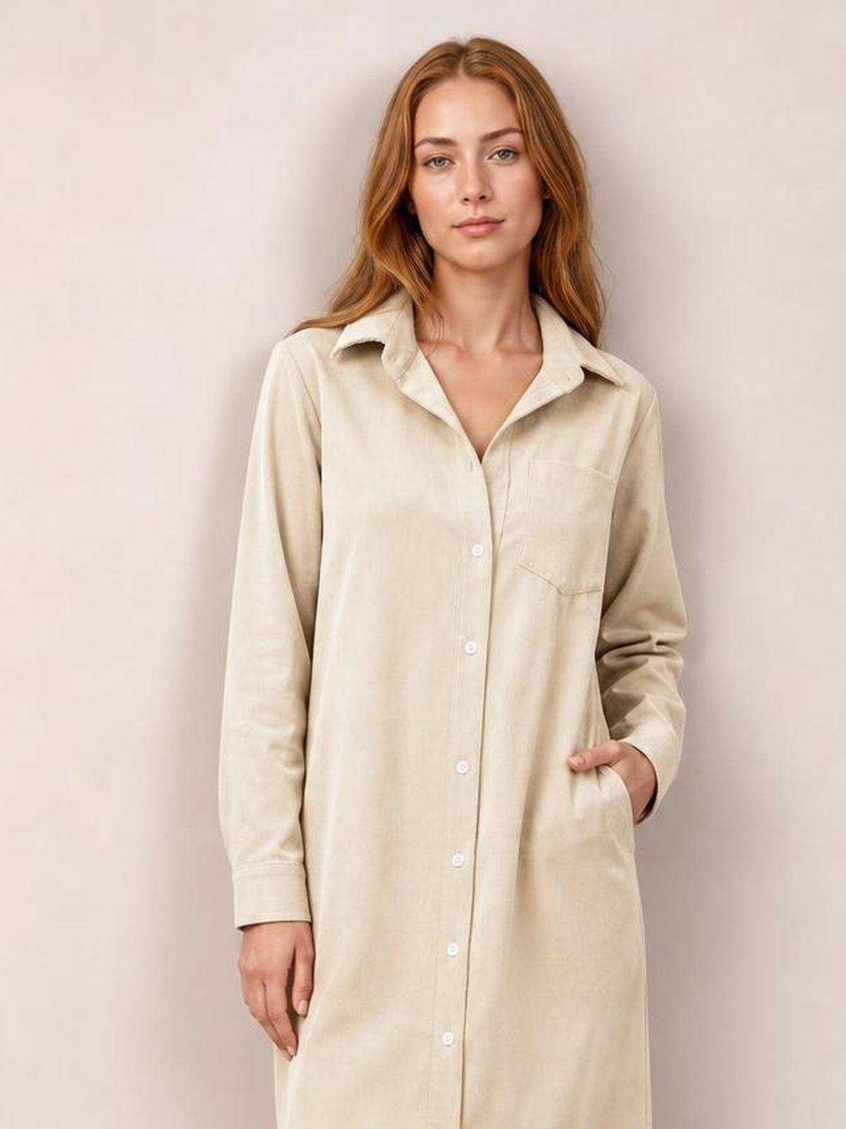 Model wears a cream corduroy shirt dress with a relaxed straight silhouette, pointed collar, long sleeves, button-down front, and side pockets.