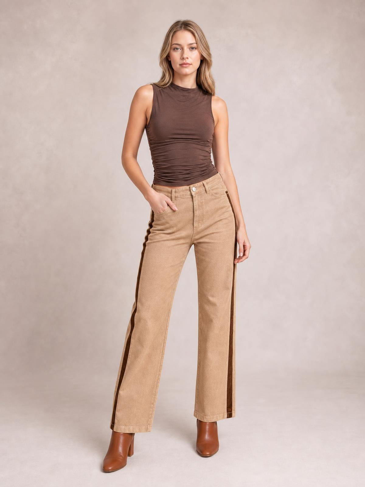 Model stands with one hand in a pocket, wearing tan corduroy colorblock straight-leg pants with dark brown side panels, belt loops, and a buttoned waist.