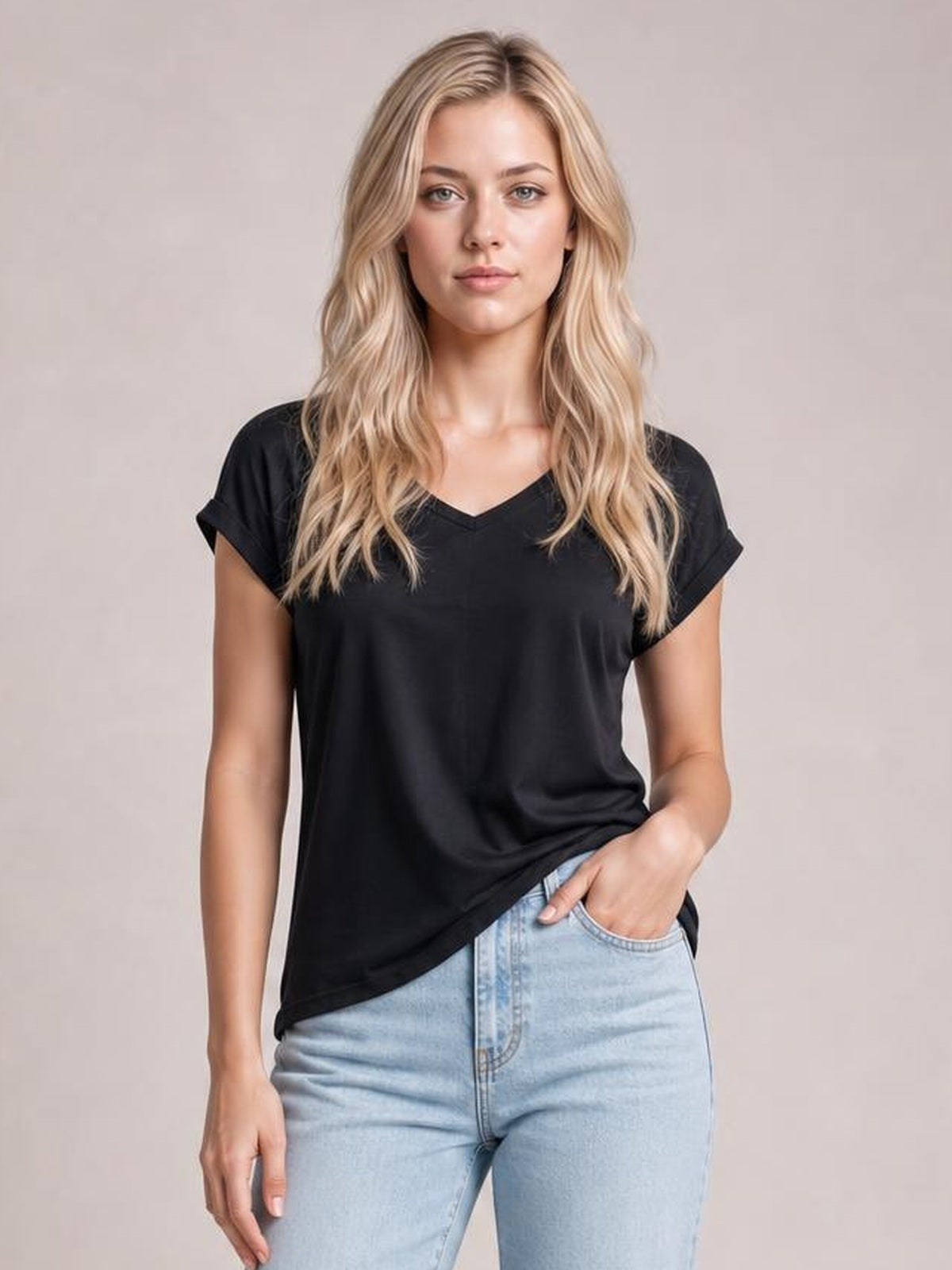 A woman models a black short-sleeve T-shirt with a V-neck, rolled sleeve cuffs, relaxed straight silhouette, and lightweight drape while posing with one hand in her pocket.
