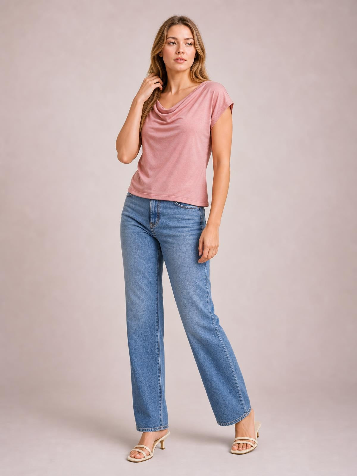 Model poses in a pink cowl neck short sleeve T-shirt with an elegant draped neckline, relaxed silhouette, and straight hem.