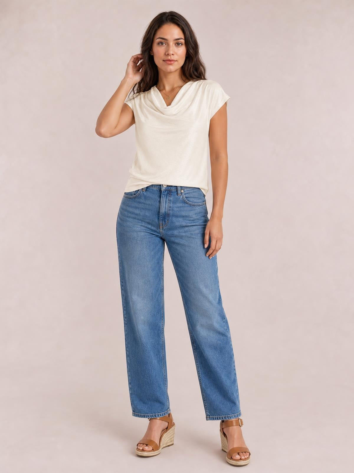 Model poses in an ivory cowl neck short sleeve T-shirt with a softly draped neckline, relaxed straight silhouette, and clean hem.