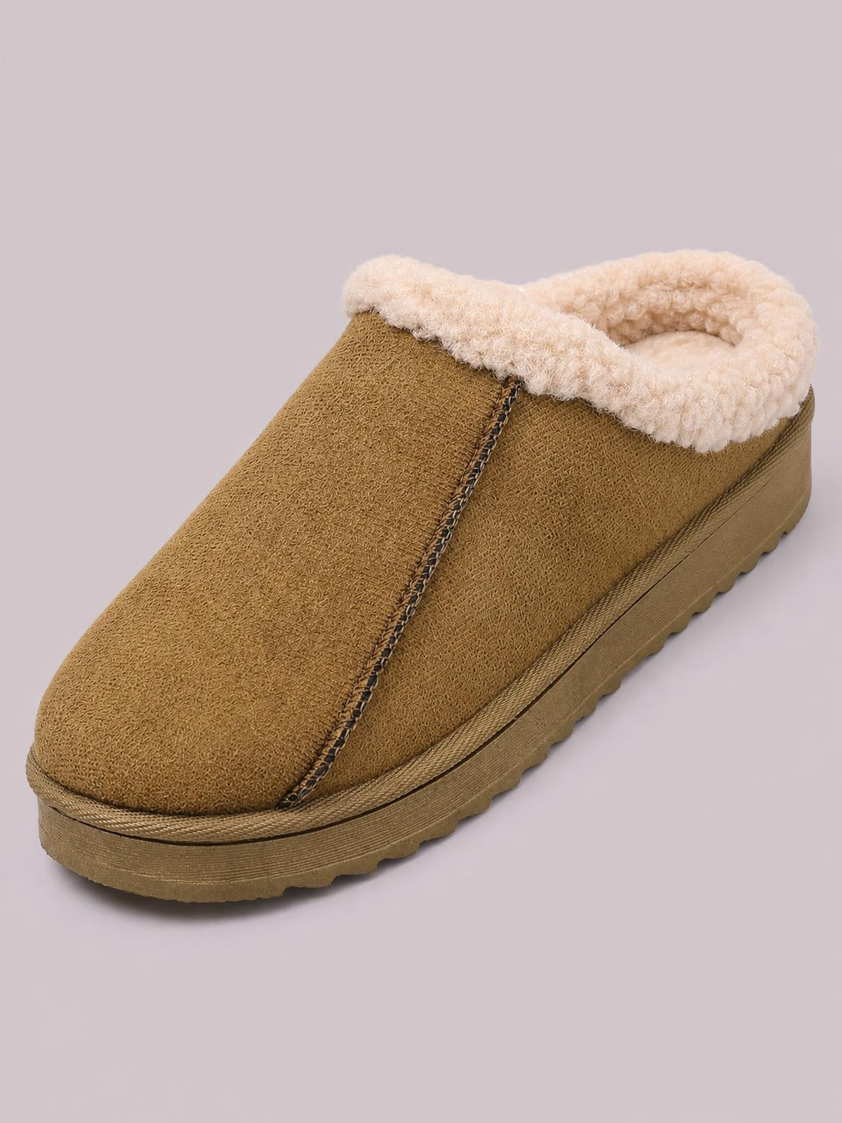 Brown suede slippers feature a rounded toe, cozy faux fur lining and collar, visible center stitching, and a flat lugged sole.