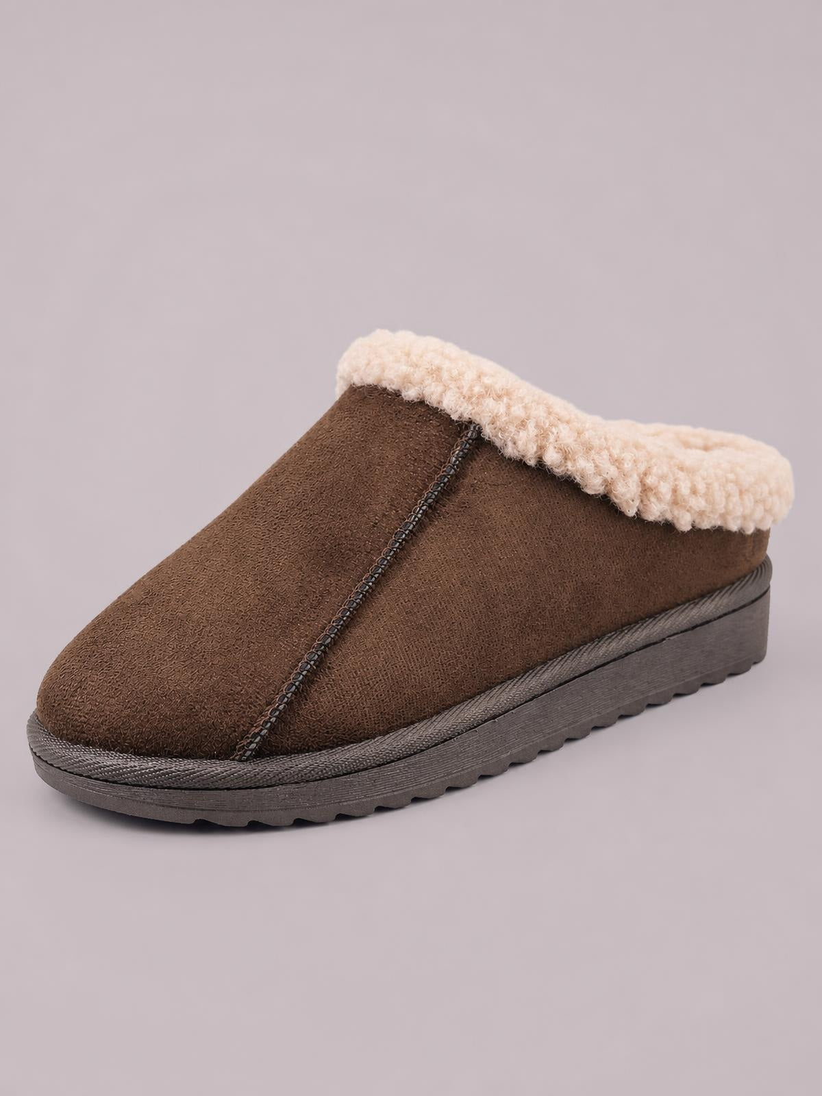 Brown suede slippers feature a cozy cream faux fur lining, stitched closed-toe construction, and a thick flat rubber sole with a rugged tread.