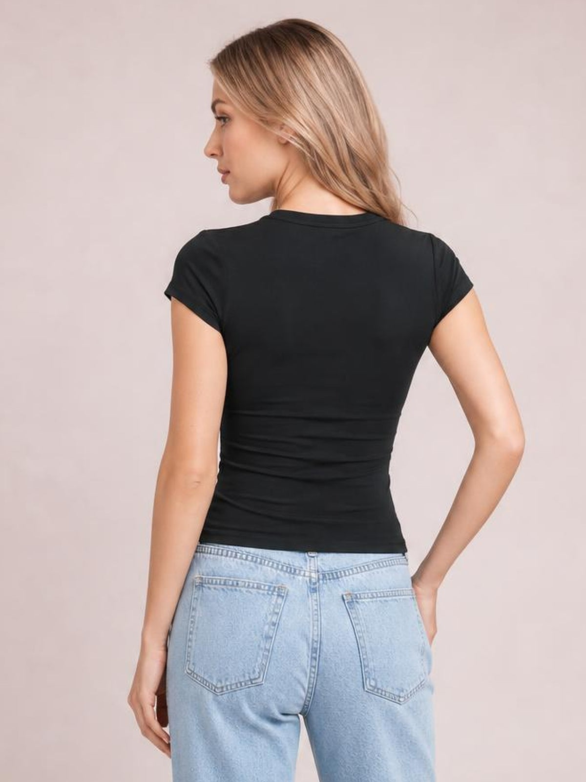 Model viewed from behind wearing a solid black crewneck short sleeve tee with a fitted silhouette, regular sleeves, and a straight hem.