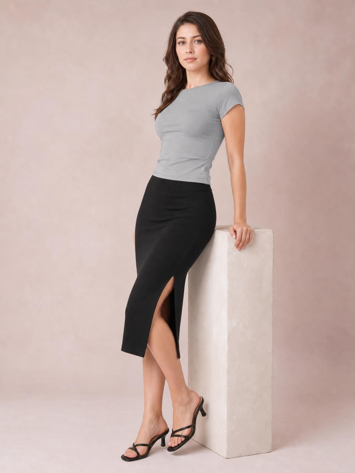 Model poses in a fitted solid gray crewneck short sleeve tee with a regular-length silhouette and short sleeves.