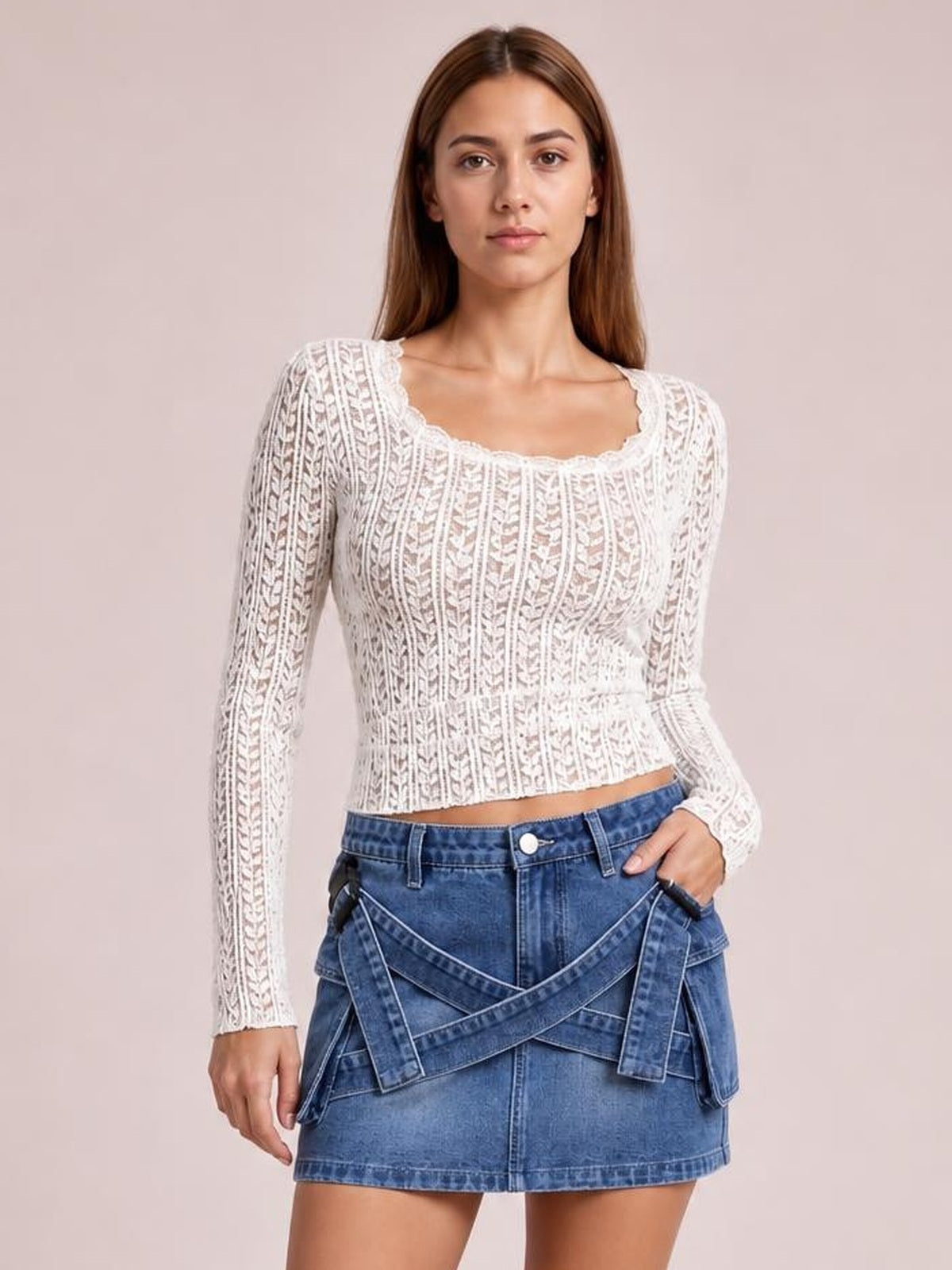 A model stands wearing a blue denim mini skirt with a criss-cross waist detail, front pockets, belt loops, button closure, and a straight silhouette.