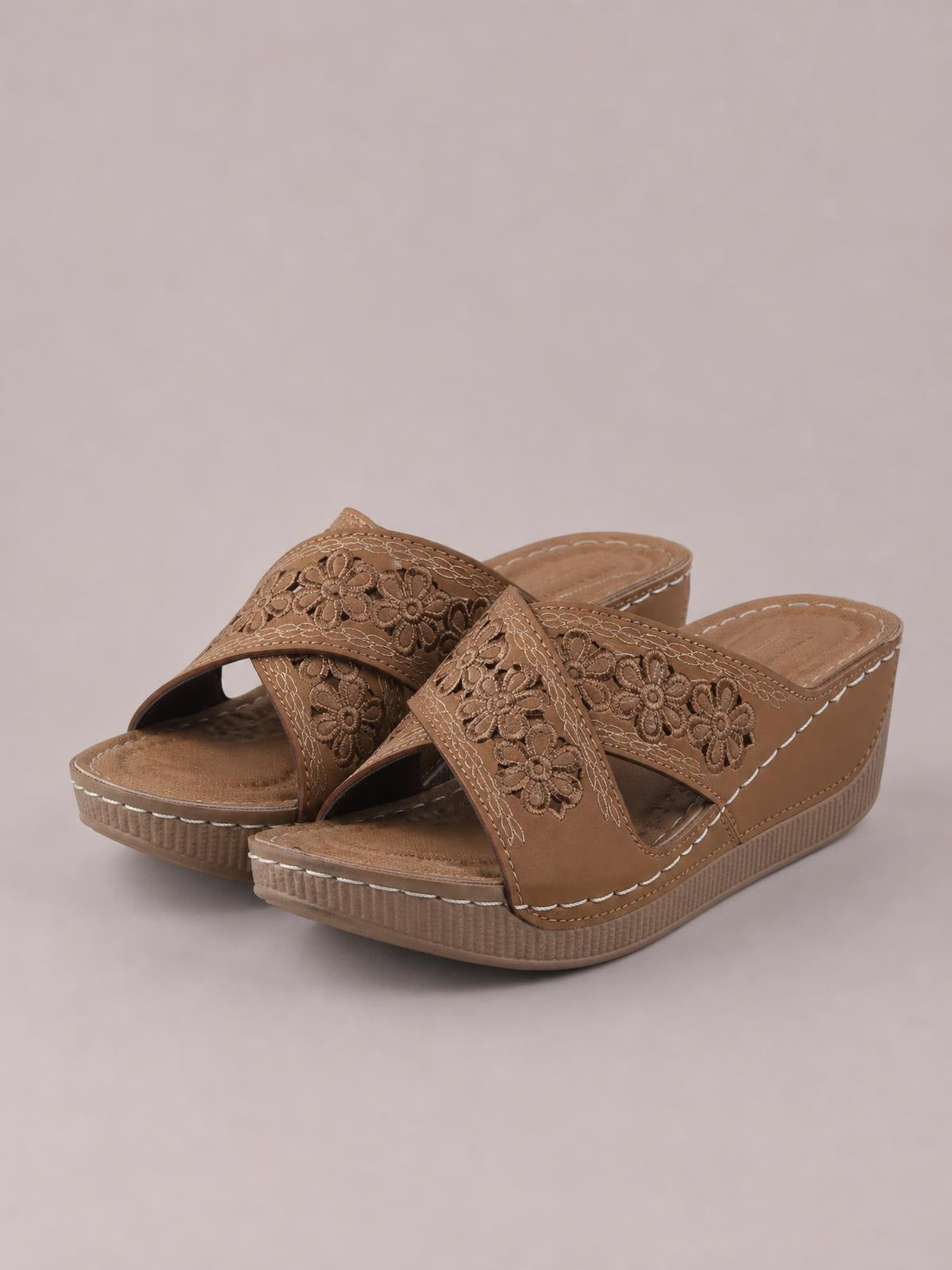 Brown crisscross flower wedge sandals feature open toes, low wedge heels, embroidered floral straps, contrast stitching, and textured rubber soles.