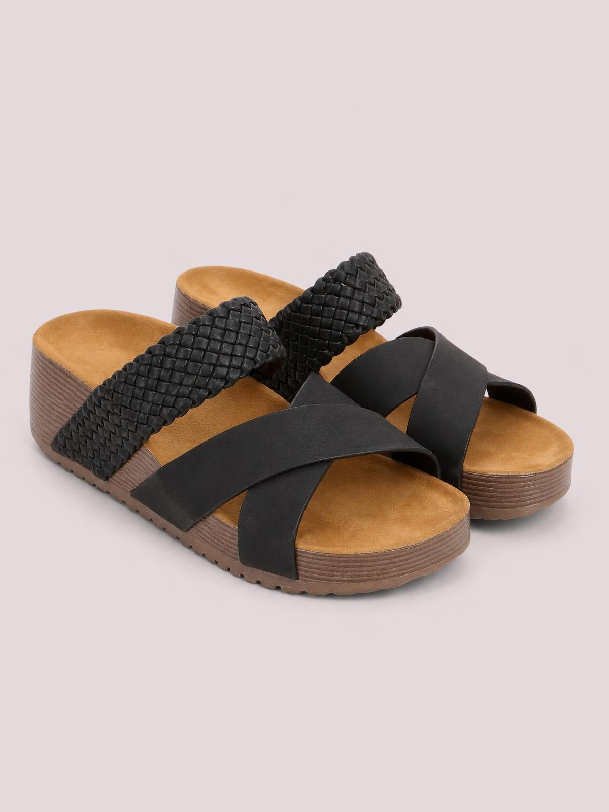 Black crisscross open-toe platform sandals feature wide smooth straps, textured woven uppers, tan footbeds, and thick layered brown soles.