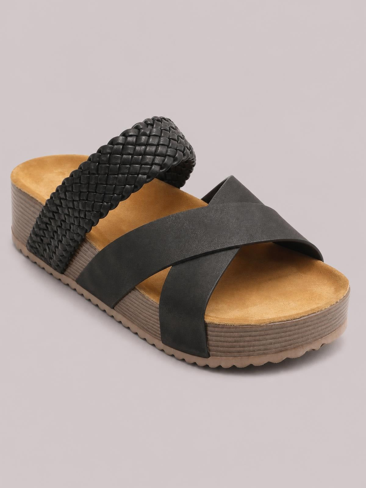Black crisscross open-toe platform sandals feature wide overlapping straps, a woven textured heel section, cushioned footbeds, and thick ridged soles.