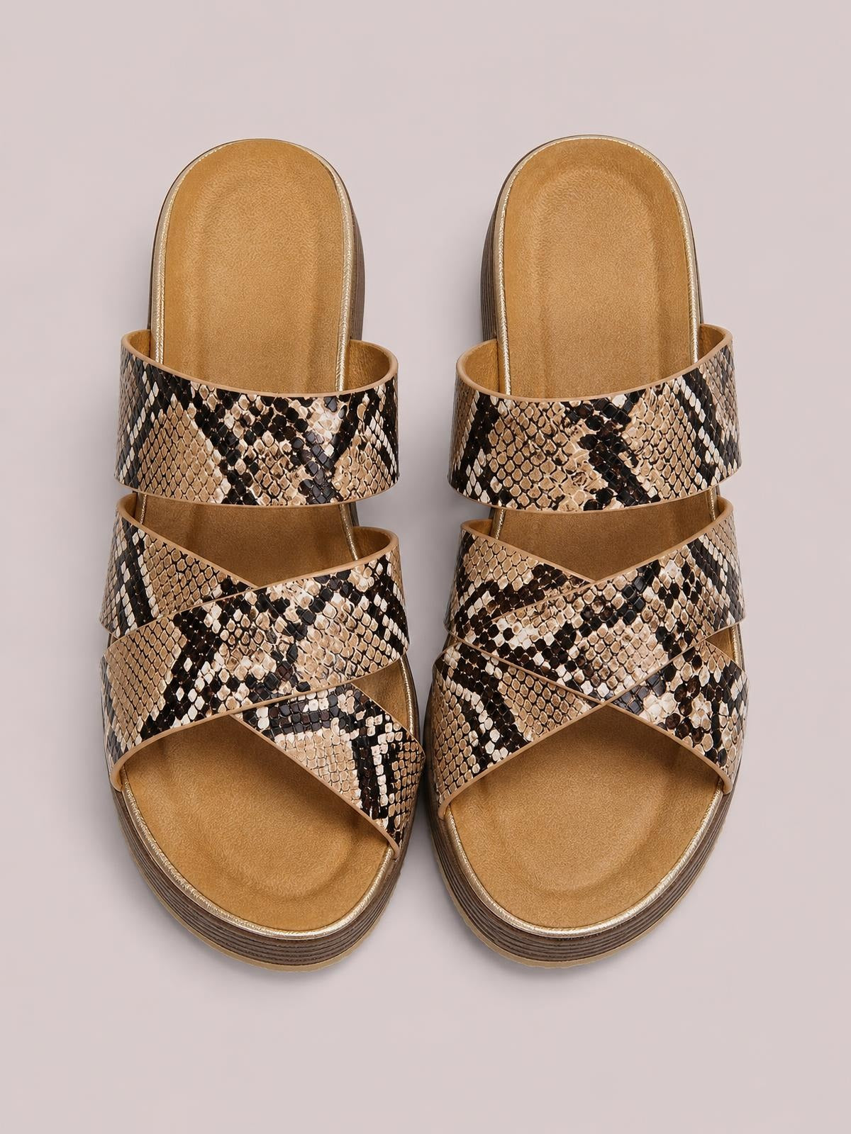 Crisscross open toe platform sandals in tan and black snakeskin print with multiple wide straps, cushioned footbeds, and layered flat soles.