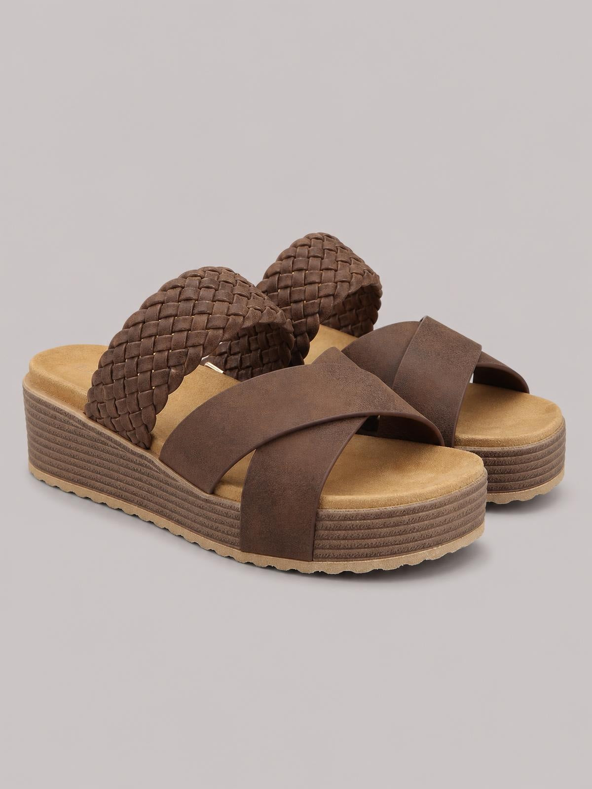 Brown crisscross open-toe platform sandals featuring wide overlapping straps, woven heel straps, cushioned footbeds, and textured flatform soles.