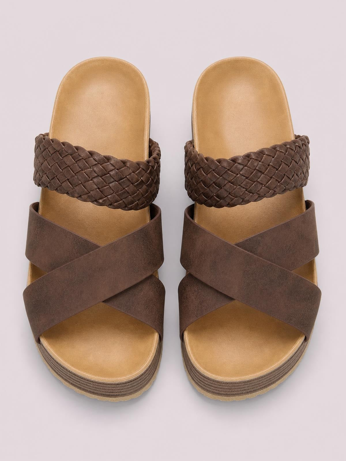 Brown crisscross open-toe platform sandals with wide overlapping straps, braided upper bands, cushioned footbeds, and layered flat soles.