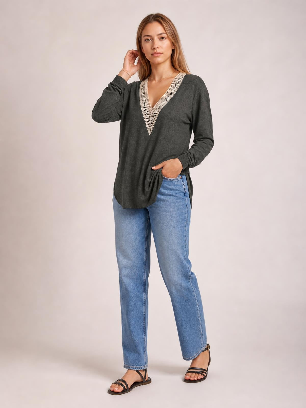 Model poses in a charcoal long-sleeve T-shirt with a contrasting crochet V-neck, relaxed silhouette, and side slit detail.