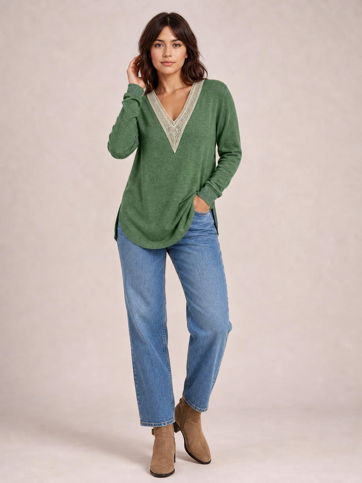 A model poses in a green crochet contrast V-neck long sleeve T-shirt with a relaxed silhouette, curved hem, and visible side slits.