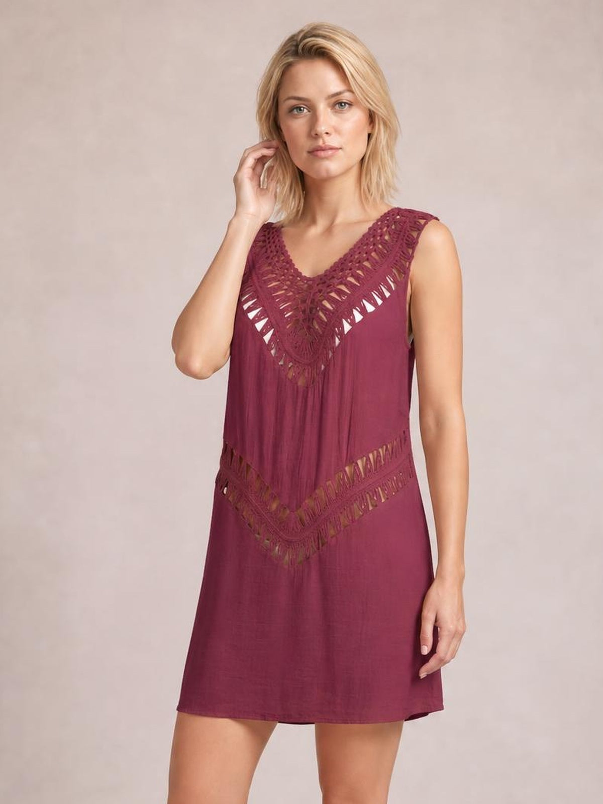 A model poses in a burgundy beach cover up dress with a sleeveless V-neck, crochet cutout detailing, and a relaxed straight silhouette.