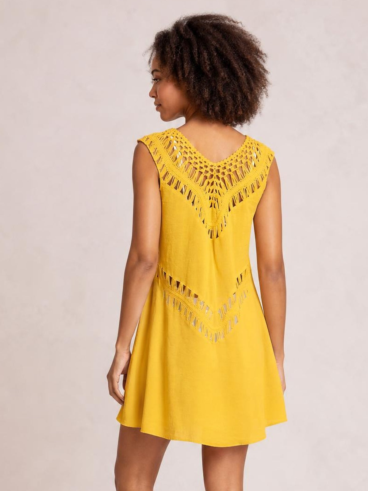 Model wears a bright yellow beach cover-up dress with crochet cutout panels, short sleeves, a relaxed A-line silhouette, and flared hem.