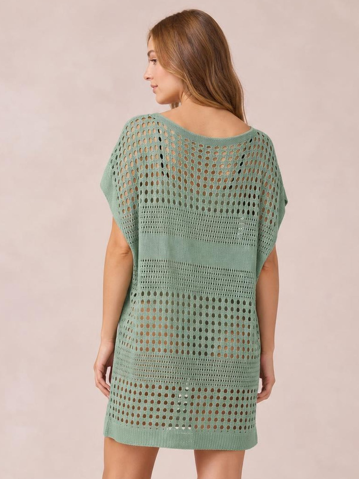 Model shown from the back in a sage green crochet knit beach cover up dress with cutout openwork, short sleeves, a relaxed straight silhouette, and hem above the knee.