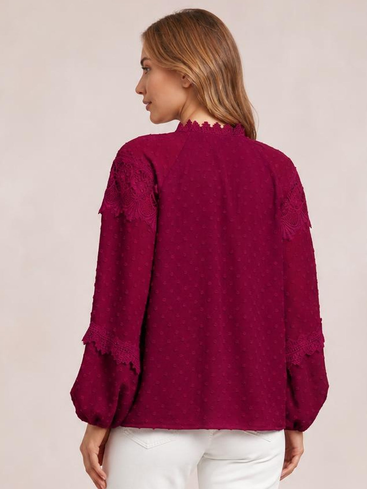 A model is shown from behind wearing a burgundy crochet blouse with long sleeves, a relaxed straight silhouette, and decorative lace-textured sleeve bands.