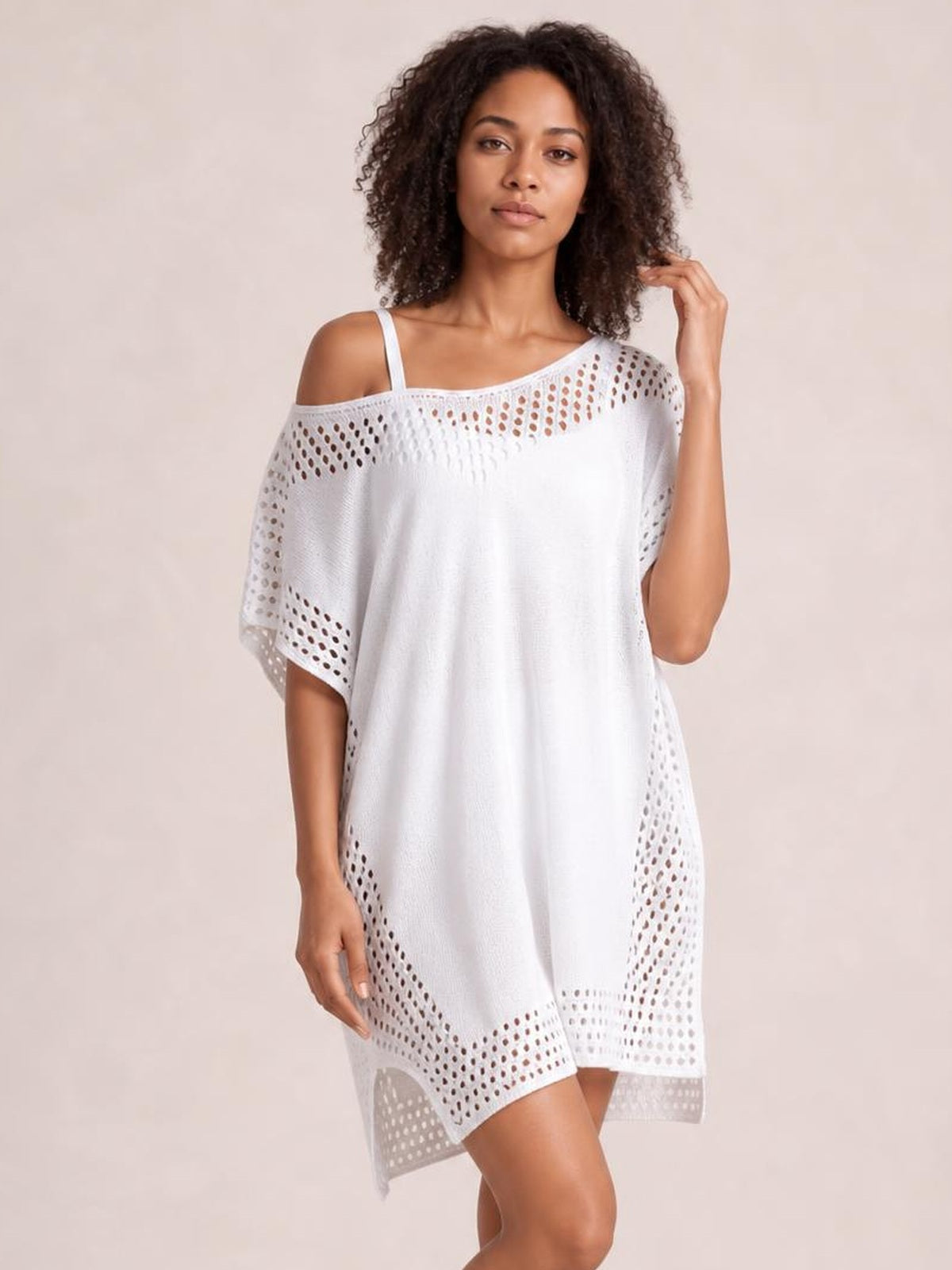 Model poses in a white crochet trim beach cover up dress with a loose tunic silhouette, cutout details, and a thigh-high side slit.