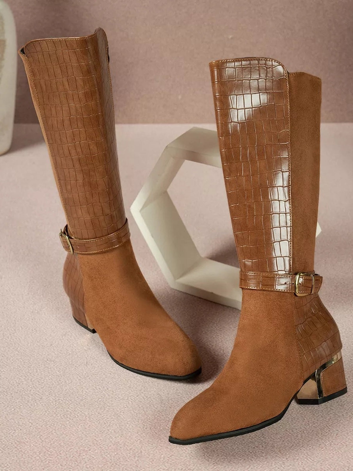 Brown crocodile-texture knee-high boots feature suede-look pointed toes, ankle buckle straps, and low block heels with contrasting trim.