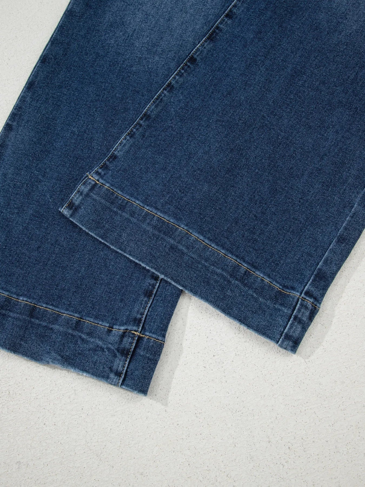 Dark blue cropped wide-leg jeans shown in close-up, highlighting the structured denim construction, flat seams, and neatly finished hems.