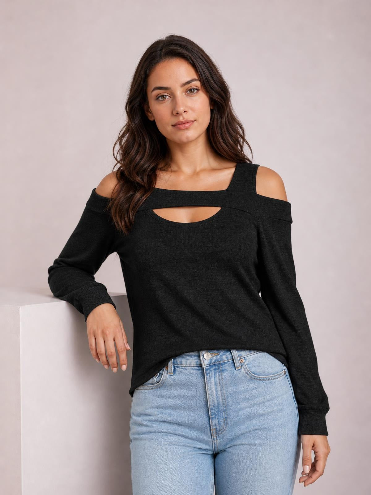 Model wearing a black solid cutout cold-shoulder top with a square neckline, long sleeves, regular-length silhouette, and exposed shoulders.
