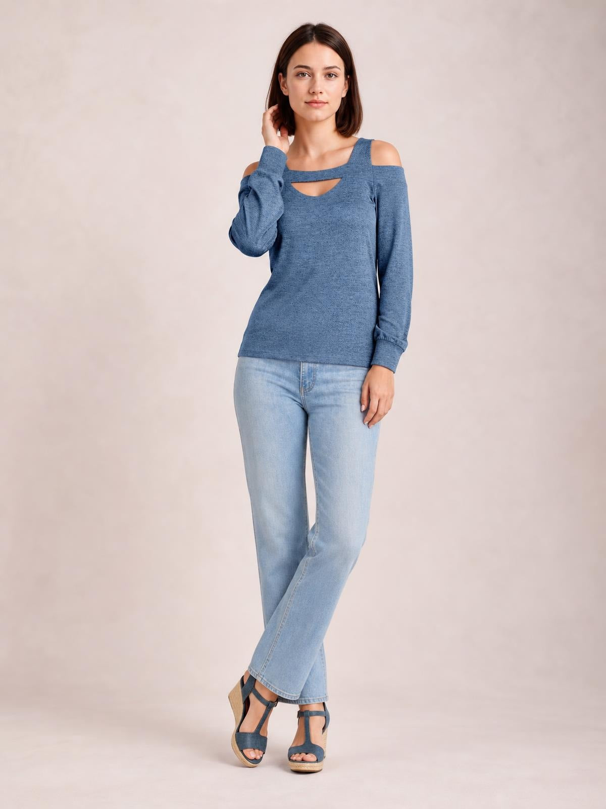 Model poses with one hand at her hair, wearing a solid blue cutout cold-shoulder top with a square neckline, long sleeves, and a regular straight silhouette.