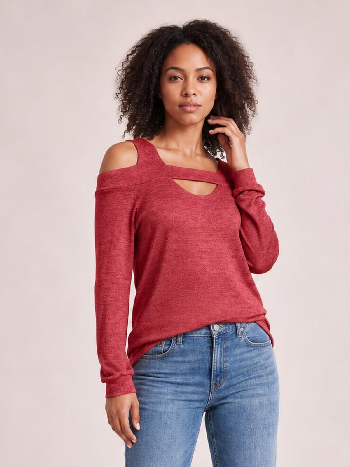 A model poses in a solid red cutout cold-shoulder top with a square neckline, long sleeves, and a relaxed regular-length silhouette.