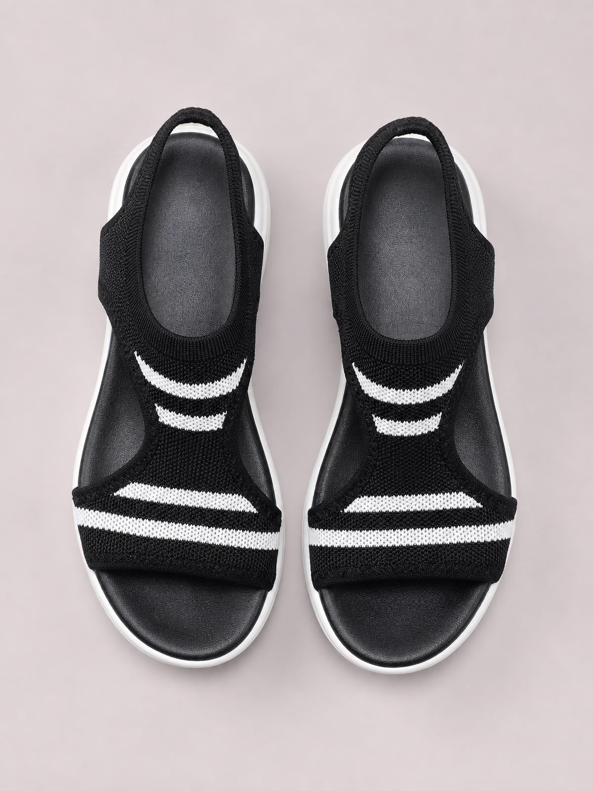 Black mesh peep toe sandals feature white striped accents, open sides, slingback straps, cushioned footbeds, and flat white-edged soles.