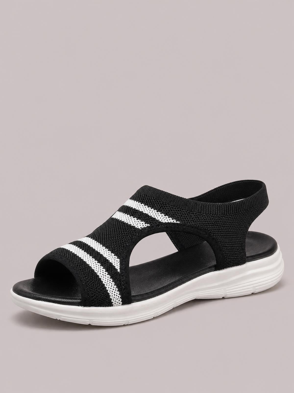 Black mesh peep toe sandals feature white stripe detailing, open cutout sides, a wide upper, and a flat platform-style white sole.