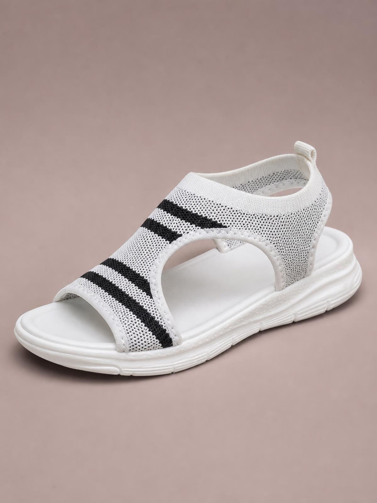 White mesh cutout sandals feature black stripe accents, an open peep toe, supportive ankle coverage, and a cushioned flat platform sole.
