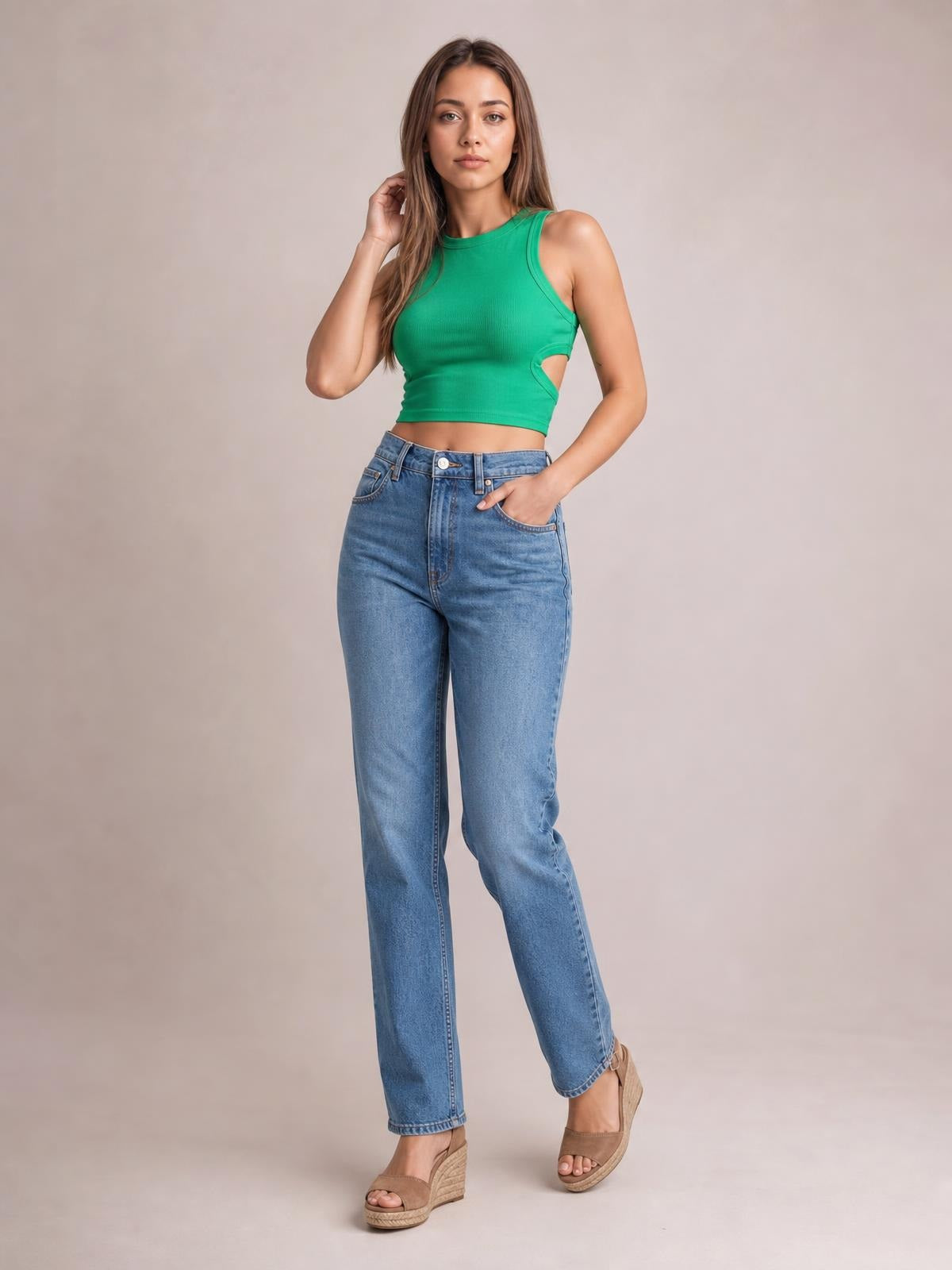 Model poses in a green cutout round neck tank with a fitted cropped silhouette, wide shoulder straps, and side cutout detail.