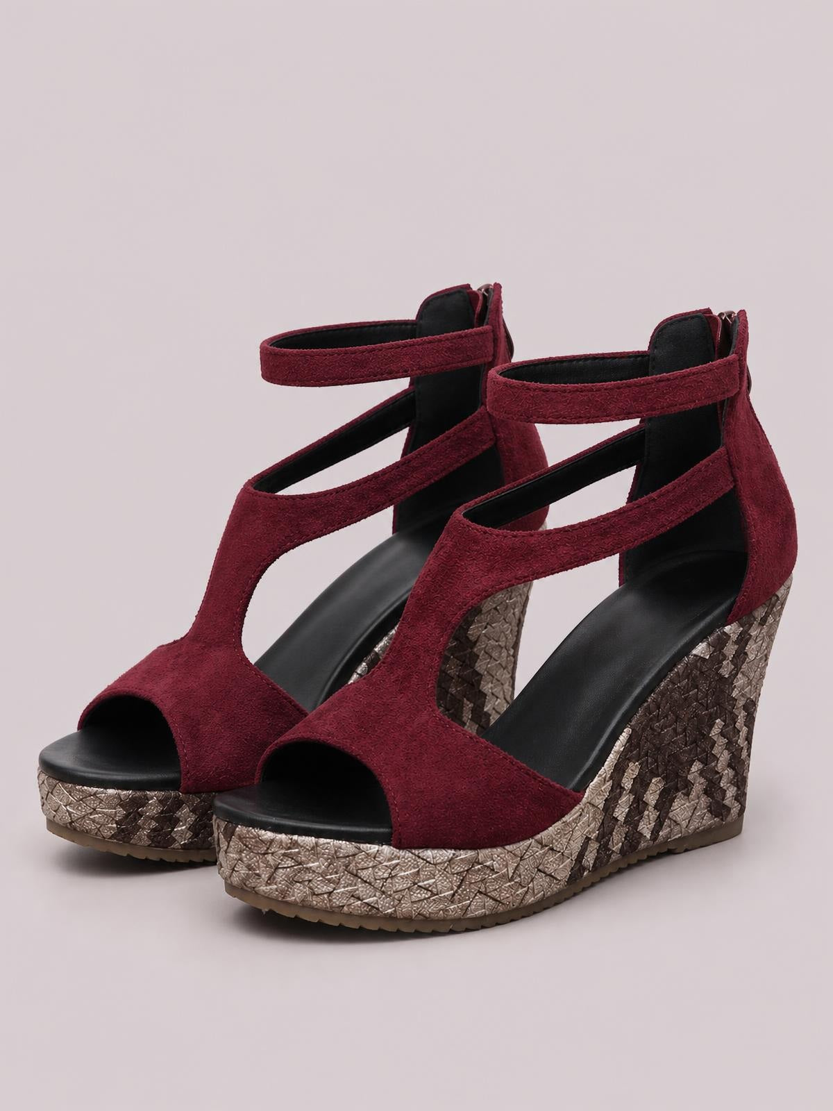 Burgundy cutout wedge platform sandals feature peep toes, ankle straps, and textured uppers with tall metallic patterned wedge heels.