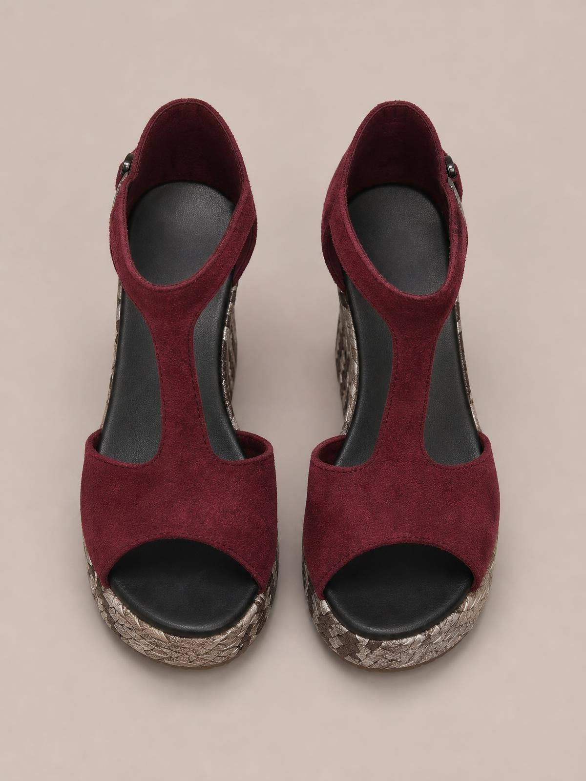 Burgundy cutout wedge platform sandals feature peep toes, wide front straps, T-bar uppers, ankle buckles, and textured metallic wedge soles.